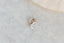 A small gold charm with lab grown diamond and hand-carved leaf details. Designed to hang on The Fae Hoop earrings.
