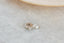 A small gold charm with lab grown diamond and hand-carved leaf details. 