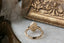 Three stone fantasy engagement ring featuring oval lab grown diamonds and medieval inspired engravings in reclaimed fine gold. A customizable engagement ring designed and crafted by The North Way Studio. This enchanting ring is shown in 14 karat yellow gold.