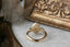 Three stone fantasy engagement ring featuring oval lab grown diamonds and medieval inspired engravings in reclaimed fine gold. A customizable engagement ring designed and crafted by The North Way Studio. This enchanting ring is shown in 14 karat yellow gold.