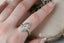 A solitaire fantasy engagement ring crafted by The North Way Studio. This fairytale ring features a lab grown marquise diamond, an engraved shield setting, and organic carvings in the gold on one side. Shown in 14 karat white gold. Shown on a woman's first finger.