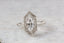 A solitaire fantasy engagement ring crafted by The North Way Studio. This fairytale ring features a lab grown marquise diamond, an engraved shield setting, and organic carvings in the gold on one side. Shown in 14 karat white gold.