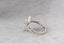 A solitaire fantasy engagement ring crafted by The North Way Studio. This fairytale ring features a lab grown marquise diamond, an engraved shield setting, and organic carvings in the gold on one side. Shown in 14 karat white gold.