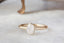 Natural cushion cut diamond with pepper inclusions set in reclaimed 14 karat yellow gold vintage-inspired collet setting.