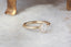 Antique style collet setting engagement ring in brushed yellow gold and opalescent diamond.