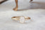 Antique inspired collet setting engagement ring in brushed yellow gold and natural opalescent diamond.