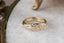 A wide flower signet band with hand-carved lavender as a symbol for protection. Shown in 10 karat yellow gold.