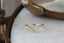 A gold wedding band with tiny diamonds sits atop a white marble table at The North Way Studio.