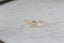 A gold wedding band with tiny diamonds is shown gleaming atop a white marble table at The North Way Studio.