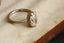 An antique-inspired solitaire ring in whittled 14 karat white gold and 3.03 carat oval brilliant cut lab grown diamond by The North Way Studio. 