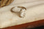 An antique-inspired solitaire ring in whittled 14 karat white gold and 3.03 carat oval brilliant cut lab grown diamond by The North Way Studio. 