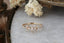 A gold ring by The North Way Studio, featuring a crown of marquise and round white diamonds in a floral pattern on a rustic, bark-textured band. Designed with a vintage-inspired elegance, this piece captures the magic-inspired aesthetic of the studio.