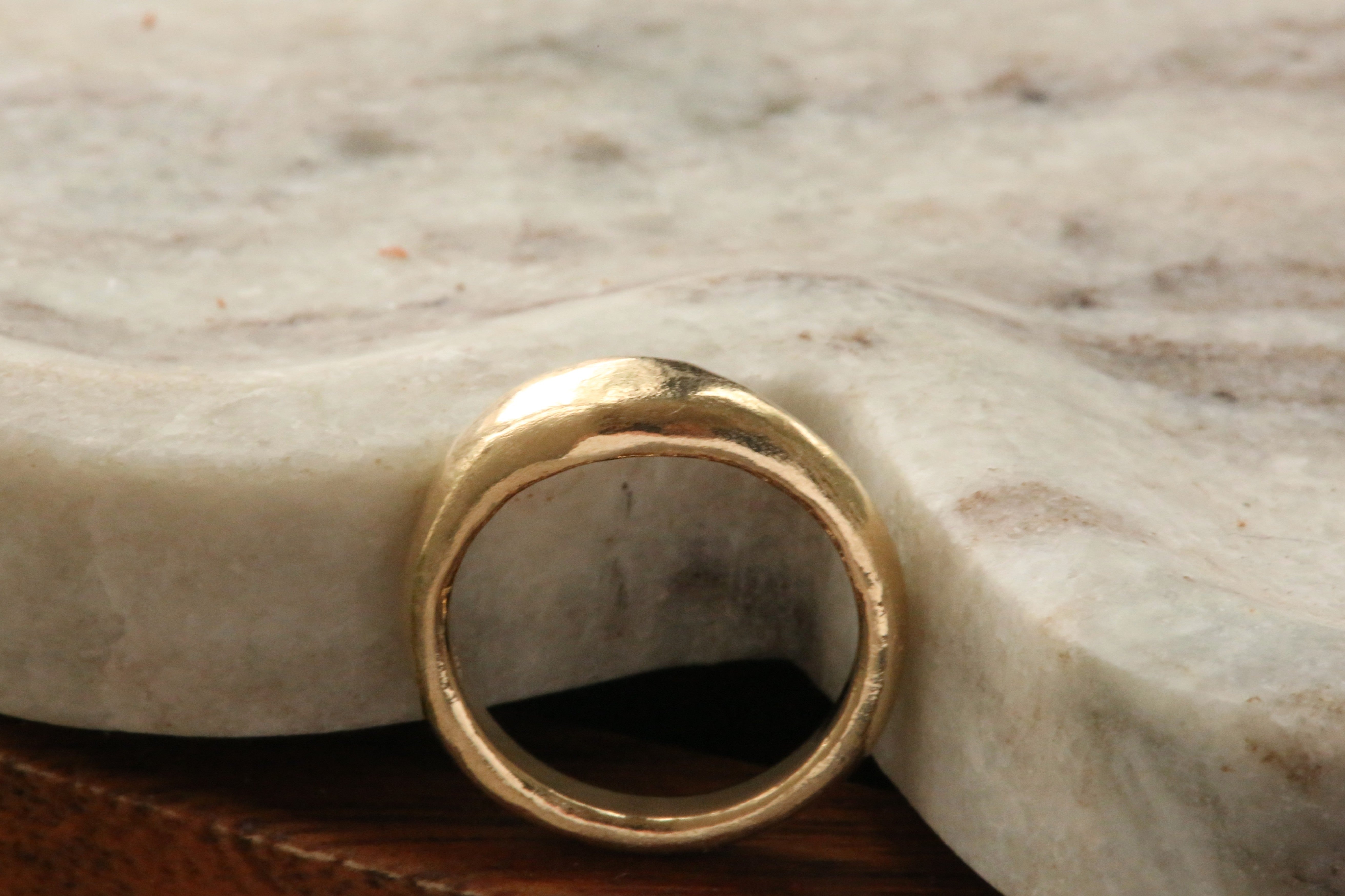 A 14 karat yellow gold signet band with ancient texture. 