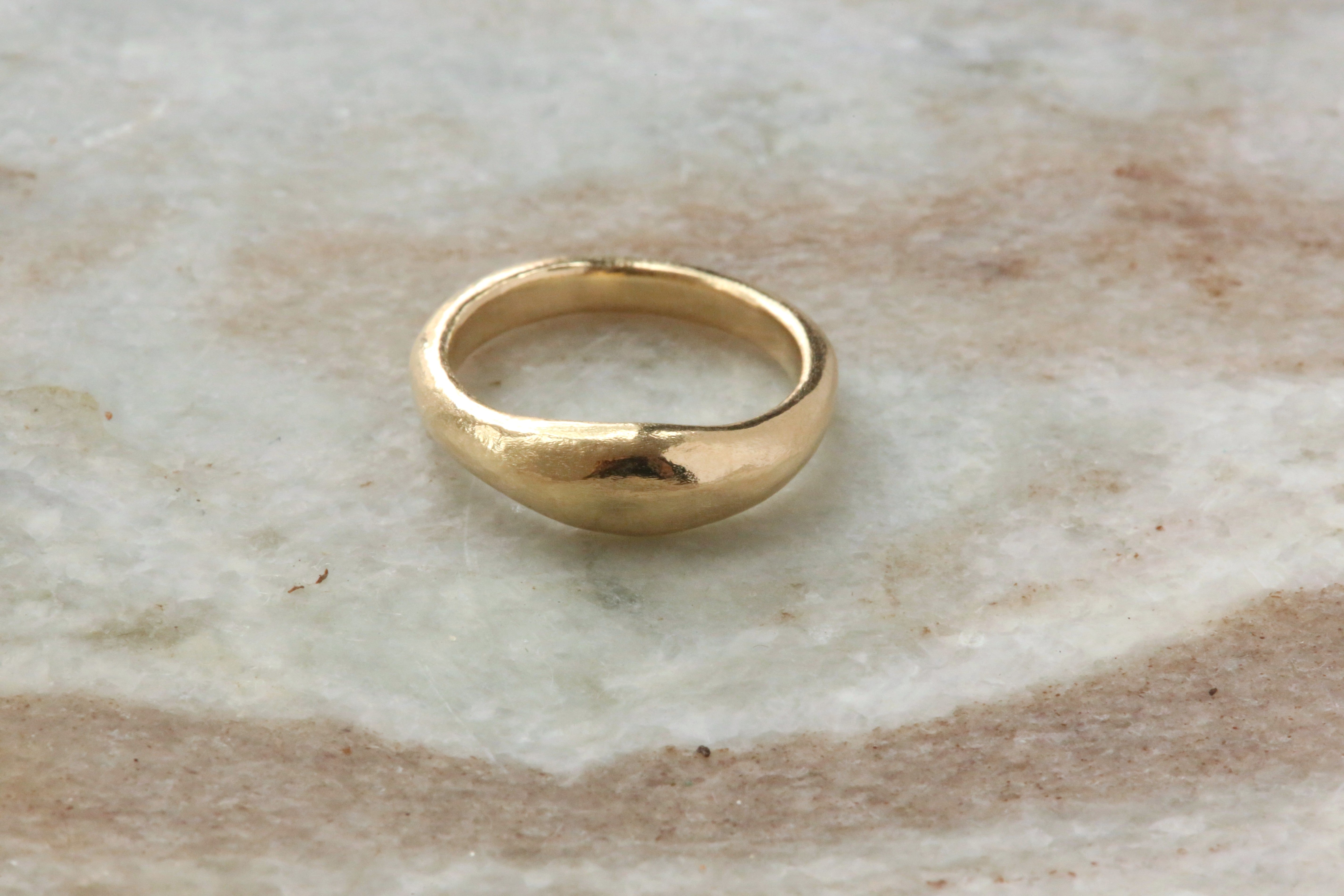 A 14 karat yellow gold signet band with ancient texture. 