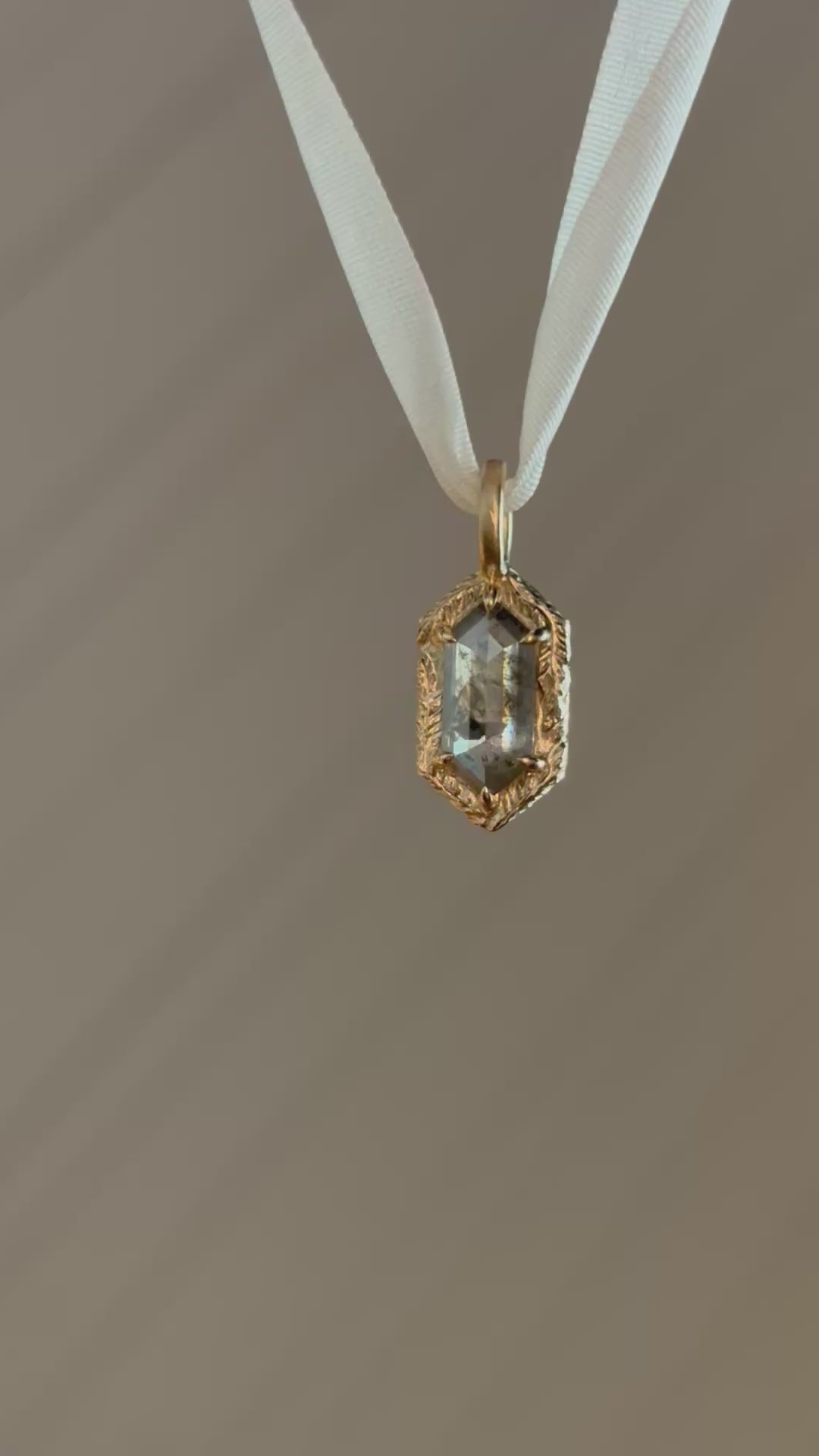 A video of the Spire Pendant in 14 karat yellow gold and natural salt and pepper diamond by The North Way Studio. 