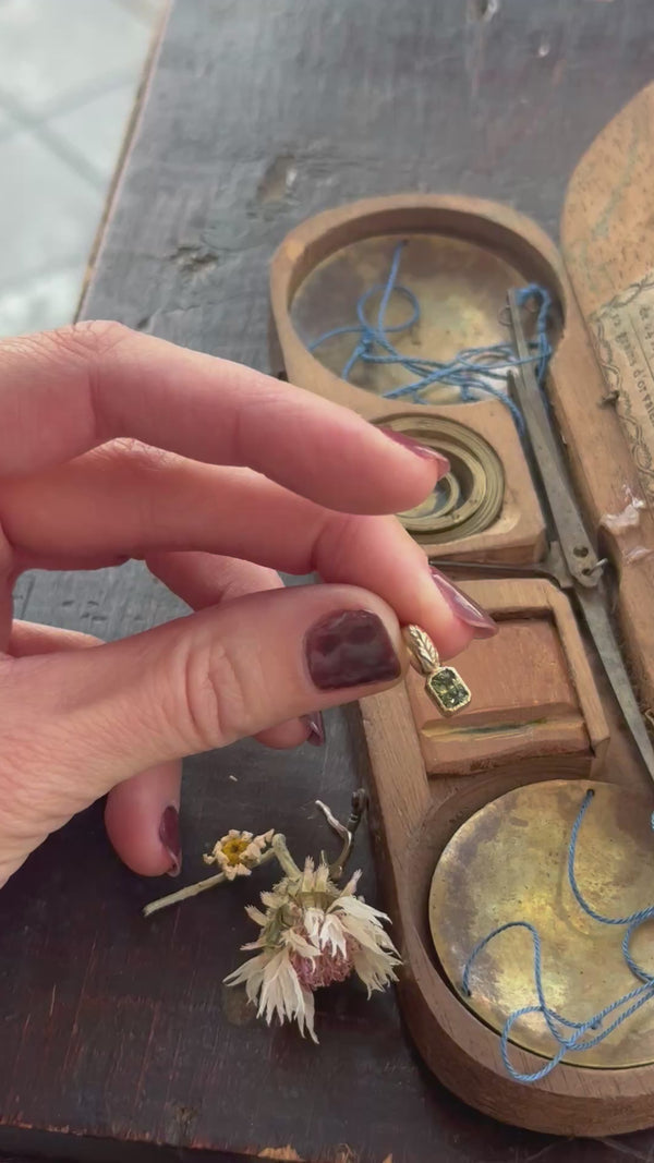 The Hag Stone pendant in reclaimed 10 karat yellow gold and natural green sapphire. 
