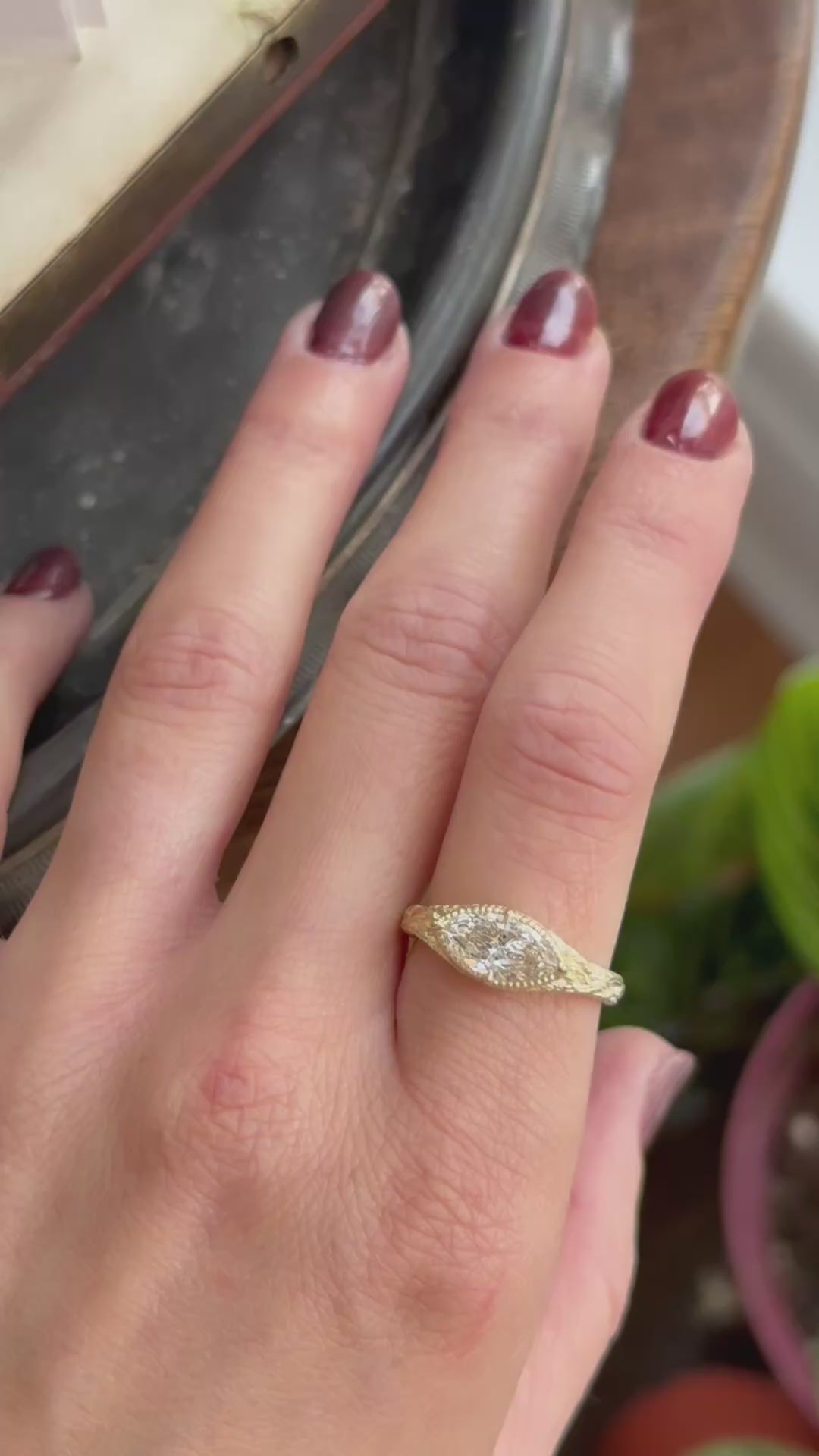 The Spire Signet in reclaimed 18 karat yellow gold and natural marquise cut Canadian diamond center. Set east to west with medieval-inspired leaves. Shown on the hand in a video. 