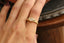 The Spire Signet in reclaimed 18 karat yellow gold and natural marquise cut Canadian diamond center. Set east to west with medieval-inspired leaves. Photographed on the hand. 